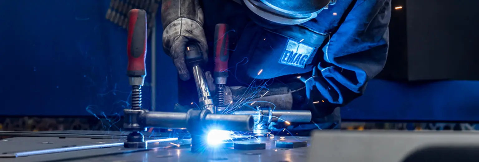 Welder performing MAG welding on a steel assembly - precision welding of welded assemblies.